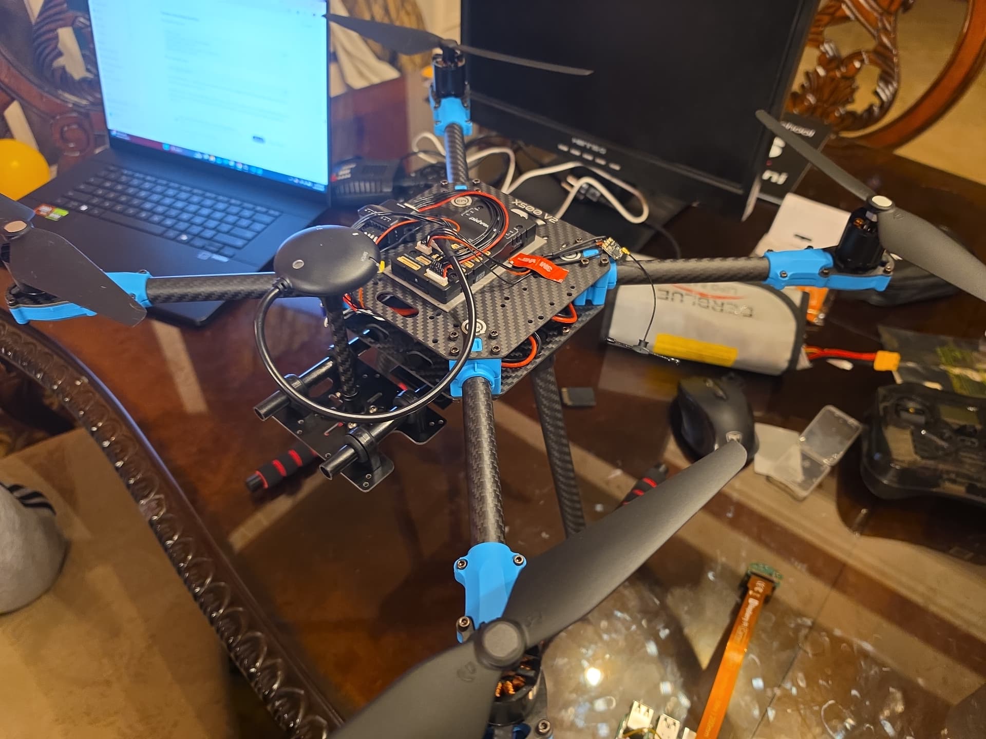 Sentinel prototype airframe under assembly on a workbench with flight controller, GPS mast, and battery wired in